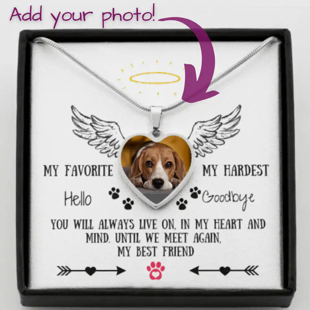 A heart-shaped pendant with a custom photo of a dog, angel wings, and sentimental text, hanging from a silver snake chain, presented in a black gift box.